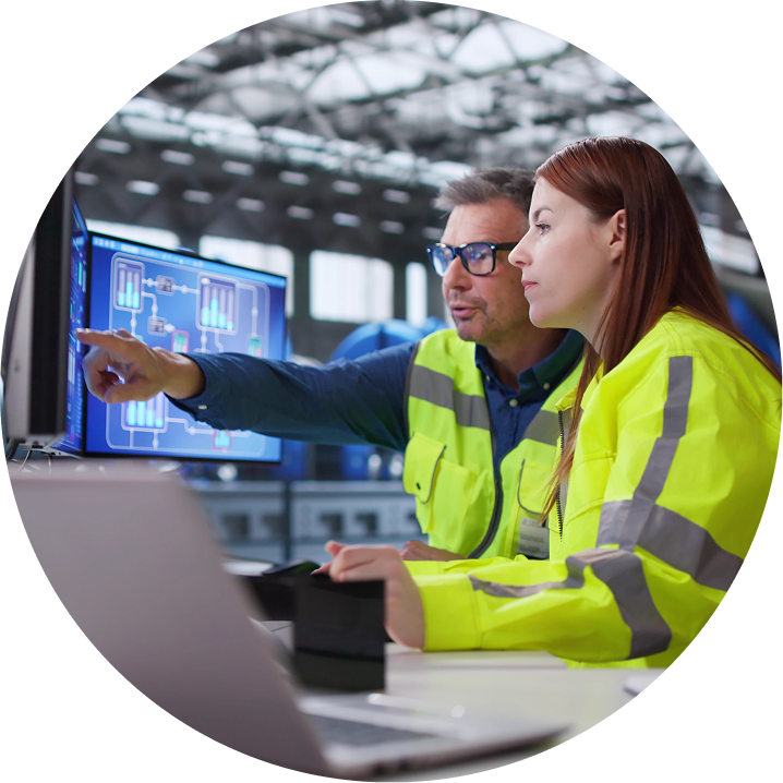 Workers in facility working and pointing at computer screen