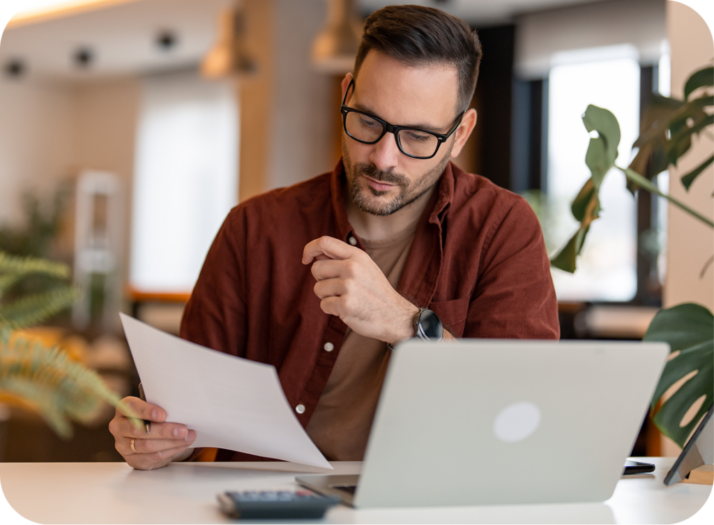 man reading and working on computer at home